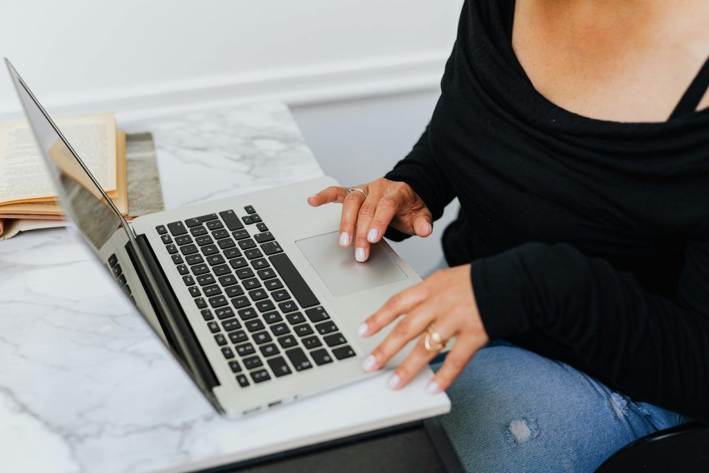 Woman typing on a laptop.